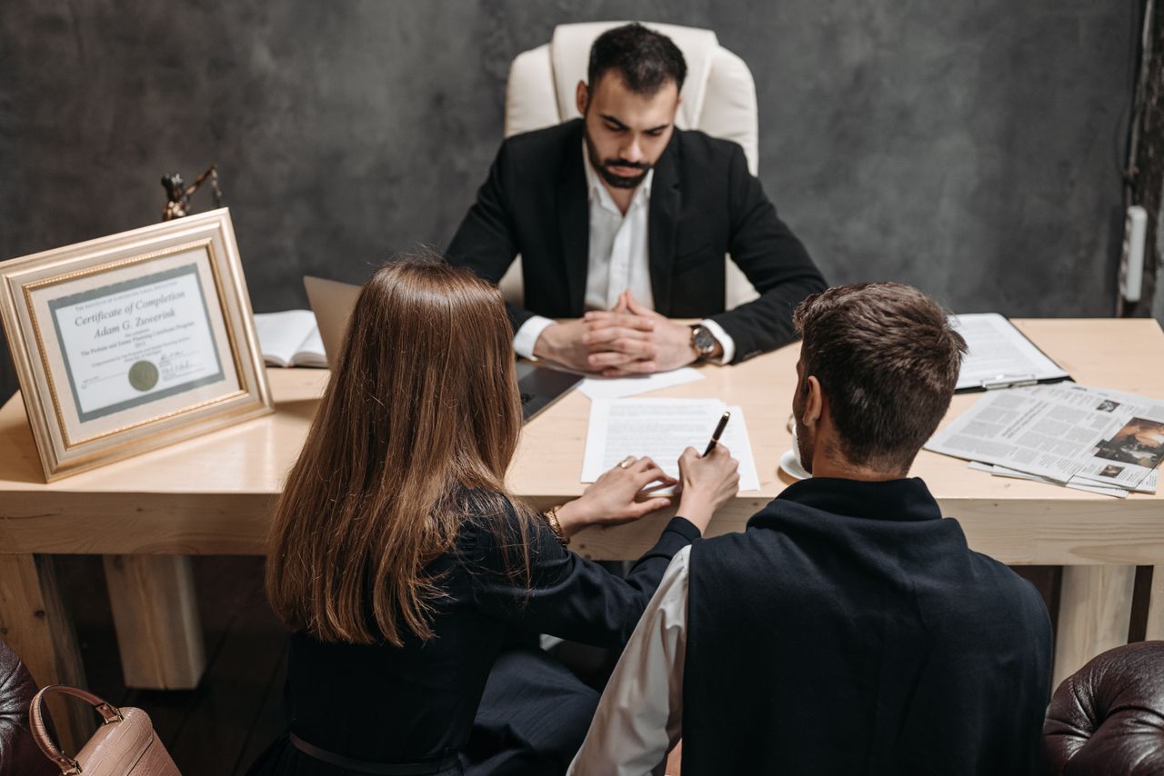 Offerings A lawyer discusses legal documents with clients in an office setting.